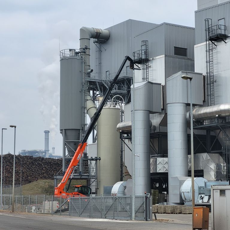 Das Bild zeigt eine Lühr-Filteranlage, die mit 2.400 Hochtemperatur-Filterschläuchen ausgestattet ist. Die Hauptaufgabe dieser Anlage besteht in der Rauchgasreinigung nach der Verbrennung von Biomasse. Die Filteranlage verfügt über eine kontinuierliche TÜV-Messung zur Überwachung der Emissionen. Nach einem erfolgten Filterwechsel wurde jeder Filterschlauch durch unseren Servicetechniker einer 100%igen Kontrolle unterzogen. Hierbei wurde der Filter mit fluoreszierendem Pulver behandelt, um eine genaue Inspektion durchzuführen. Durch regelmäßige professionelle Wartung wird sichergestellt, dass die Emissionswerte eingehalten werden. Bei Bedarf werden Filter gewechselt und dieser Prozess dokumentiert. Dies gewährleistet eine effiziente und umweltfreundliche Funktion der Filteranlage.